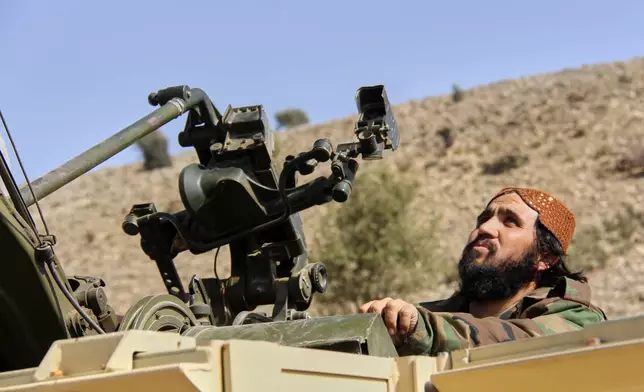 A Taliban fighter looks up while manning an armed pickup truck at the Afghan side of the Ghulam Khan crossing with Pakistan in Khost province, Afghanistan, Friday, Feb. 27, 2026. (AP Photo/Saifullah Zahir)