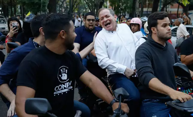 Opposition leader Juan Pablo Guanipa rides on the back of a motorcycle after his release from prison in Caracas, Venezuela, Sunday, Feb. 8, 2026.(AP Photo/Cristian Hernandez)
