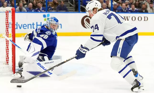 Toronto Maple Leafs center Bobby McMann (74) tries to shoot on Tampa Bay Lightning goaltender Andrei Vasilevskiy (88) during the first period of an NHL hockey game Wednesday, Feb. 25, 2026, in Tampa, Fla. (AP Photo/Chris O'Meara)