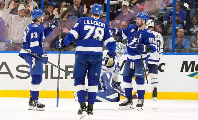 Tampa Bay Lightning right wing Nikita Kucherov (86) celebrates his goal against the Toronto Maple Leafs with center Gage Goncalves (93) and defenseman Emil Lilleberg (78) during the third period of an NHL hockey game Wednesday, Feb. 25, 2026, in Tampa, Fla. (AP Photo/Chris O'Meara)