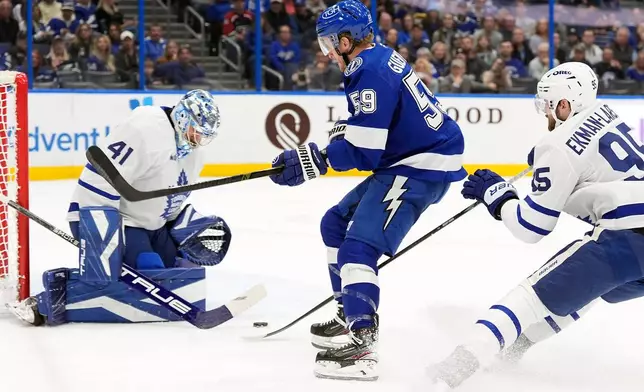 Tampa Bay Lightning center Jake Guentzel (59) gets off a shot on Toronto Maple Leafs goaltender Anthony Stolarz (41) during the second period of an NHL hockey game Wednesday, Feb. 25, 2026, in Tampa, Fla. (AP Photo/Chris O'Meara)