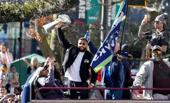 Seattle Seahawks players celebrate during the team's NFL football Super Bowl 60 parade and celebration, Wednesday, Feb. 11, 2026, in Seattle. (AP Photo/Stephen Brashear)