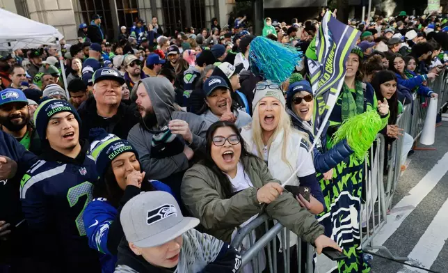Seattle Seahawks cheer as they wait for the team's NFL football Super Bowl 60 parade and celebration to begin on Wednesday, Feb. 11, 2026, in Seattle. (AP Photo/John Froschauer)