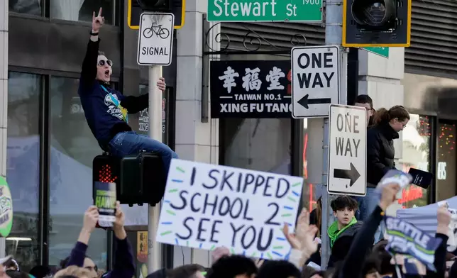 Seattle Seahawks fans cheer during the team's NFL football Super Bowl 60 parade and celebration, Wednesday, Feb. 11, 2026, in Seattle. (AP Photo/John Froschauer)