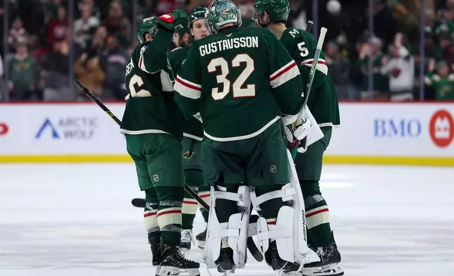 Minnesota Wild players congratulate Minnesota Wild goaltender Filip Gustavsson (32) after the team's overtime win in an NHL hockey game against the Montréal Canadiens Monday, Feb. 2, 2026, in St. Paul, Minn. (AP Photo/Matt Krohn)