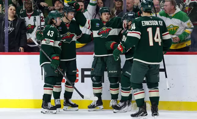 Minnesota Wild defenseman Brock Faber, center, celebrates with teammates after his goal during the third period of an NHL hockey game against the Montréal Canadiens, Monday, Feb. 2, 2026, in St. Paul, Minn. (AP Photo/Matt Krohn)