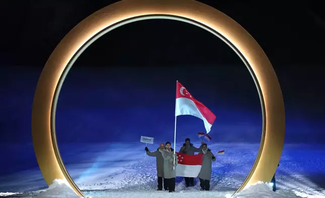Flag bearer Faiz Basha Munwar Basha of Singapore leads the team, during the Olympic opening ceremony, at the 2026 Winter Olympics, in Livigno, Italy, Friday, Feb. 6, 2026. (Cameron Spencer, Pool Photo via AP)