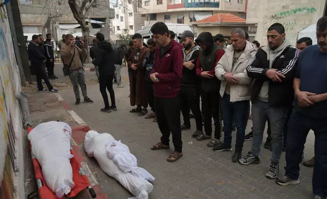 Palestinians mourn over the dead who were killed in an Israeli military strike, at Shifa Hospital in Gaza City, Wednesday, Feb. 4, 2026. (AP Photo/Jehad Alshrafi)