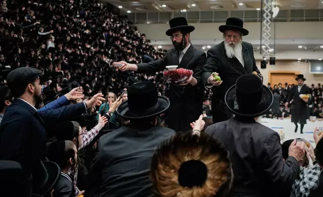 Ultra-Orthodox Jews from the Belz Hasidic dynasty pass plates of fruit during celebrations marking the Jewish holiday of Tu Bishvat, the "New Year of the Trees," in Jerusalem Monday, Feb. 2, 2026. (AP Photo/Ohad Zwigenberg)