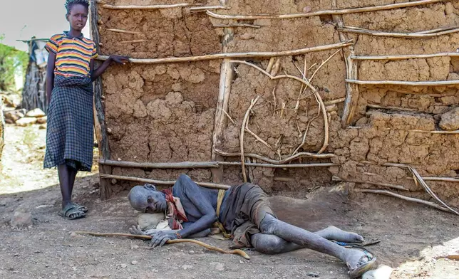 Achukwa Lotukoi Nakine, 87, lies beside his grandson amid a prolonged drought in Nadunga Village, Turkana County, Kenya, Friday, Feb. 6, 2026. (AP Photo/Patrick Ngugi)