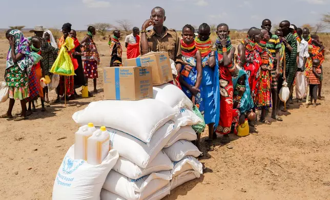 Locals queue to receive food aid as severe drought continues, in Nalemkais Village, Turkana County, Kenya, Sunday, Feb. 8, 2026. (AP Photo/Patrick Ngugi)