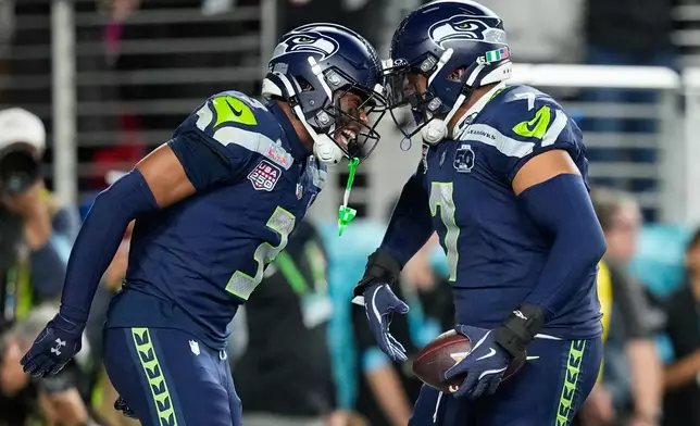 Seattle Seahawks linebacker Uchenna Nwosu (7) celebrates his touchdown on a fumble recovery with safety Nick Emmanwori (3) during the second half of the NFL Super Bowl 60 football game against the New England Patriots, Sunday, Feb. 8, 2026, in Santa Clara, Calif. (AP Photo/Julio Cortez)