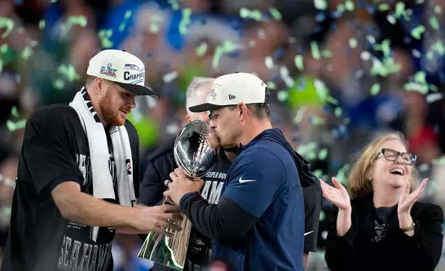 Seattle Seahawks head coach Mike Macdonald kisses the Lombardi Trophy between quarterback Sam Darnold and Seattle Seahawks chair Jody Allen after the NFL Super Bowl 60 football game, Sunday, Feb. 8, 2026, in Santa Clara, Calif. (AP Photo/Sue Ogrocki)