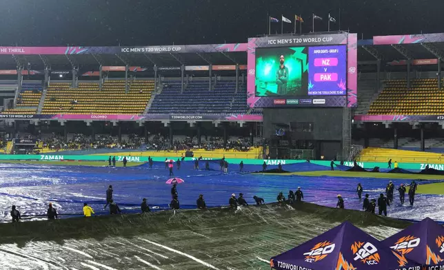 Groundsmen cover the field as it begins to rain before the start of the T20 World Cup cricket match between New Zealand and Pakistan in Colombo, Sri Lanka, Saturday, Feb. 21, 2026. (AP Photo/Eranga Jayawardena)