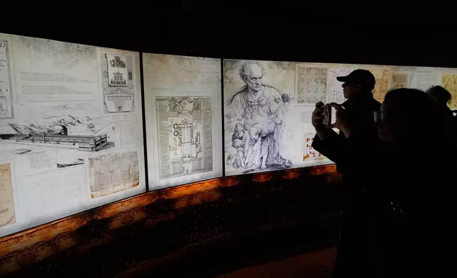 Journalists attend the opening of an exhibition titled "Ultra Visibilia" on the occasion of the 400th anniversary of the dedication of St. Peter's Basilica at the Vatican, Monday, Feb. 16, 2026. (AP Photo/Gregorio Borgia)