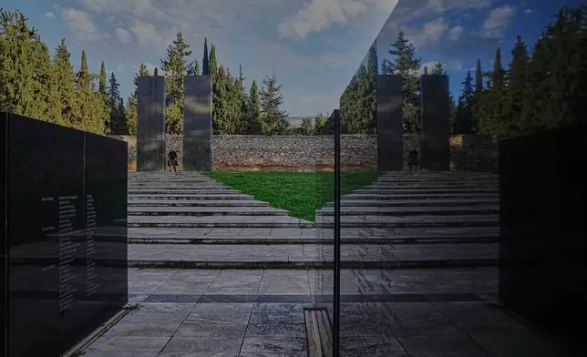 A man walks through a memorial site at the Kaisariani Shooting Range in the Kaisariani suburb of Athens, Monday, Feb. 16, 2026, where 200 Greek communist political prisoners were executed by Nazi forces on May 1, 1944. (AP Photo/Petros Giannakouris)