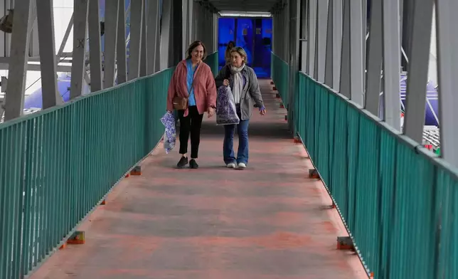 Women walk across an overpass in downtown Tehran, Iran, Tuesday, Feb. 24, 2026. (AP Photo/Vahid Salemi)