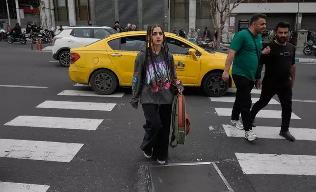People cross a square in downtown Tehran, Iran, Tuesday, Feb. 24, 2026. (AP Photo/Vahid Salemi)