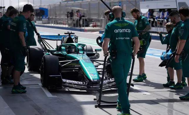 Aston Martin driver Lance Stroll of Canada gets pushed back into his garage during a Formula One pre-season test at the Bahrain International Circuit in Sakhir, Bahrain, Wednesday, Feb. 11, 2026. (AP Photo/Altaf Qadri)