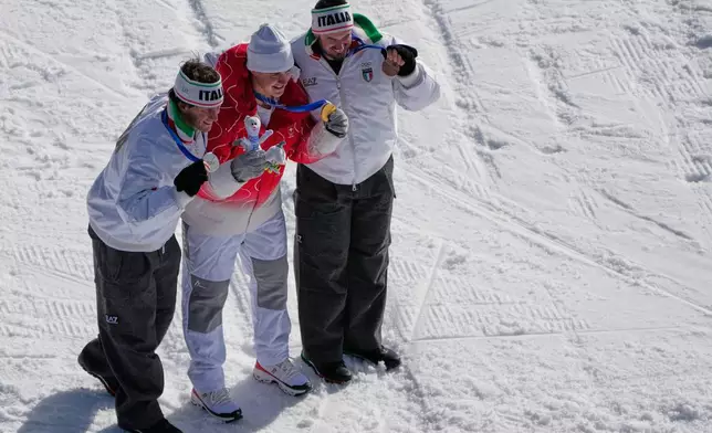 Switzerland's Franjo von Allmen, center, gold, Italy's Giovanni Franzoni, left, silver, and Italy's Dominik Paris, bronze, pose after an alpine ski, men's downhill race, at the 2026 Winter Olympics, in Bormio, Italy, Saturday, Feb. 7, 2026. (AP Photo/John Locher)