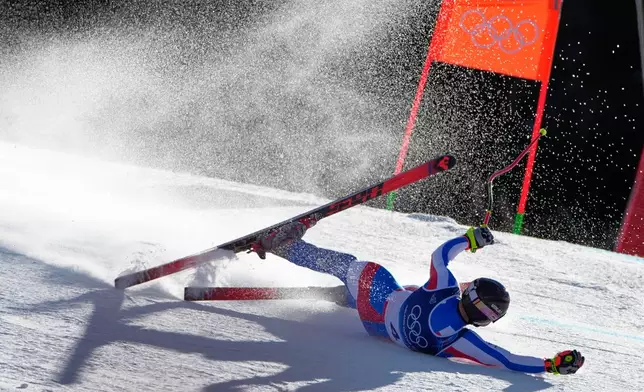 France's Maxence Muzaton falls as he speeds down the course during an alpine ski, men's downhill race, at the 2026 Winter Olympics, in Bormio, Italy, Saturday, Feb. 7, 2026. (AP Photo/John Locher)