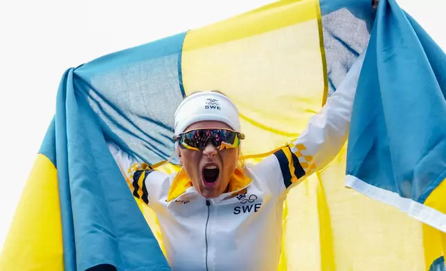 Frida Karlsson, of Sweden, celebrates after finishing the cross country skiing women's 10km interval start free at the 2026 Winter Olympics, in Tesero, Italy, Thursday, Feb. 12, 2026. (AP Photo/Kirsty Wigglesworth)