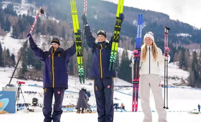 Silver medalist Ebba Andersson, of Sweden, from left, gold medalist Frida Karlsson, of Sweden, and bronze medalist Jessie Diggins, of the United States, pose after finishing the cross country skiing women's 10km interval start free at the 2026 Winter Olympics, in Tesero, Italy, Thursday, Feb. 12, 2026. (AP Photo/Kirsty Wigglesworth)
