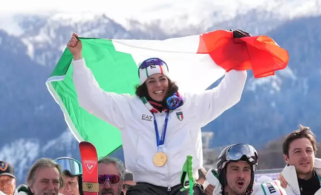 Italy's Federica Brignone celebrates winning the gold medal in an alpine ski, women's super-G race, with the team, at the 2026 Winter Olympics, in Cortina d'Ampezzo, Italy, Thursday, Feb. 12, 2026. (AP Photo/Jacquelyn Martin)