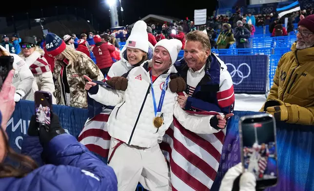 Gold medalist United States' Alex Ferreira, center, celebrates alongside US Ski Team CEO Sophie Goldschmidt, left, and team board of trustee member Ronald Kruszewski after the men's freestyle skiing halfpipe finals at the 2026 Winter Olympics, in Livigno, Italy, Friday, Feb. 20, 2026. (AP Photo/Gregory Bull)
