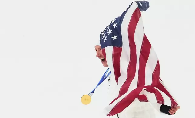 Gold medalist United States' Alex Ferreira celebrates with an American flag after winning the men's freestyle skiing halfpipe finals at the 2026 Winter Olympics, in Livigno, Italy, Friday, Feb. 20, 2026. (AP Photo/Lindsey Wasson)