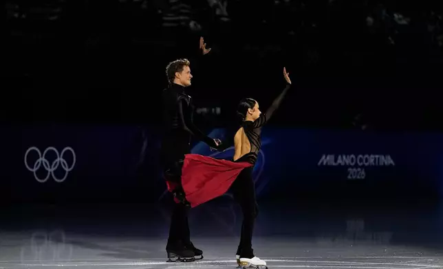 Madison Chock and Evan Bates of the United States wave to the crowd before the figure skating ice dance team event at the 2026 Winter Olympics, in Milan, Italy, Saturday, Feb. 7, 2026. (AP Photo/Natacha Pisarenko)