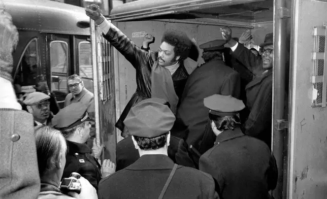 FILE - Rev. Jesse Jackson raises a clenched fist from a police van after he and 11 others from Operation Breadbasket were arrested during a sit-in at the Atlantic and Pacific Tea Co., offices in New York, Feb. 2, 1971. (AP Photo/Marty Lederhandler, file)