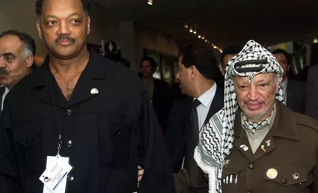 FILE - Civil rights activist Jesse Jackson, left, walks with Palestinian leader Yasser Arafat after the opening ceremony of the World Conference Against Racism in Durban, South Africa, Aug. 31, 2001. (AP Photo/Jose Goitia, File)