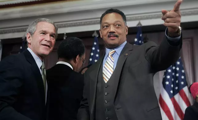 FILE - President George W. Bush speaks with Rev. Jesse Jackson, right, after signing a bill in the Eisenhower Executive Office Building, Dec. 1, 2005, authorizing a statue of civil rights leader Rosa Parks be placed in the U.S. Capitol's Statuary Hall. (AP Photo/Ron Edmonds, File)