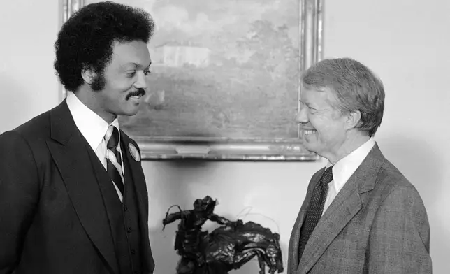 FILE - President Jimmy Carter speaks with the Rev. Jesse Jackson at the White House in Washington, April 4, 1979. (AP Photo/Bob Daugherty, File)