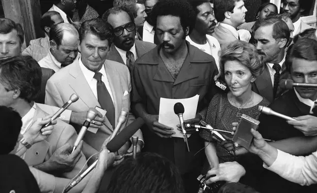 FILE - Republican presidential nominee Gov. Ronald Reagan talks with the Rev. Jesse L. Jackson, director of Operation Push, outside the organization's headquarters in Chicago, Aug. 5,1980. Nancy Reagan is at right. Reagan met with Jackson for an hour then departed for Los Angeles.(AP Photo/Fred Jewell, File)