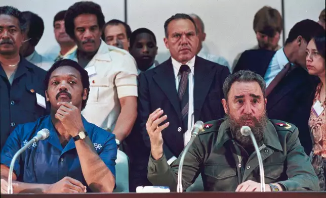 FILE - Cuban Premier Fidel Castro, right, and Rev. Jesse Jackson talk to the international media during a joint news conference, following the end of their marathon meeting at Havana's National Palace, June 27, 1984, when it was announced that 22 Americans would be freed from Cuban jails. Others are unidentified. (AP Photo/Charles Tasnadi, File)