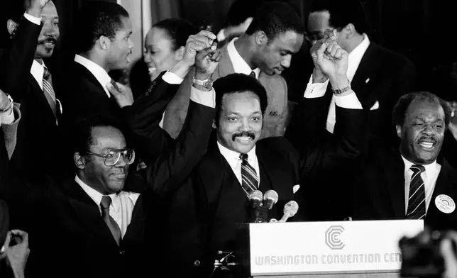 FILE - Jesse Jackson holds his hands up after announcing he will seek the Democratic nomination for president, with his campaign chairman Mayor Richard Hatcher, left, of Gary Ind., and Mayor Marion Barry of Washington, D.C., in Washington, Nov. 3, 1983. (AP Photo/Scott Stewart, File)