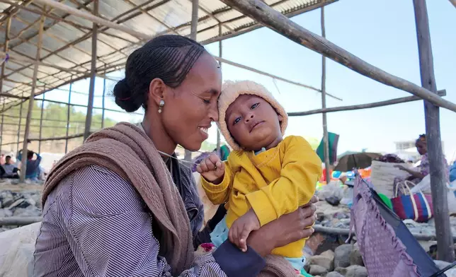 A woman holds her child at a street market in Wukro in the Tigray region of northern Ethiopia, Tuesday, Jan. 27, 2026. (AP Photo/Jody Ray)