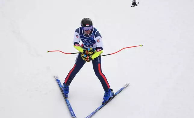 A drone flies above Monaco's Arnaud Alessandria during an alpine ski, men's super-G race, at the 2026 Winter Olympics, in Bormio, Italy, Wednesday, Feb. 11, 2026. (AP Photo/Rebecca Blackwell)