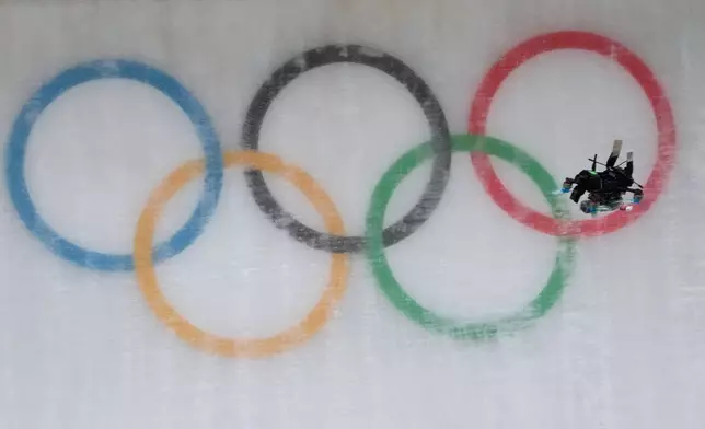 A drone flies down the track during a men's single luge run at the 2026 Winter Olympics, in Cortina d'Ampezzo, Italy, Sunday, Feb. 8, 2026. (AP Photo/Aijaz Rahi)