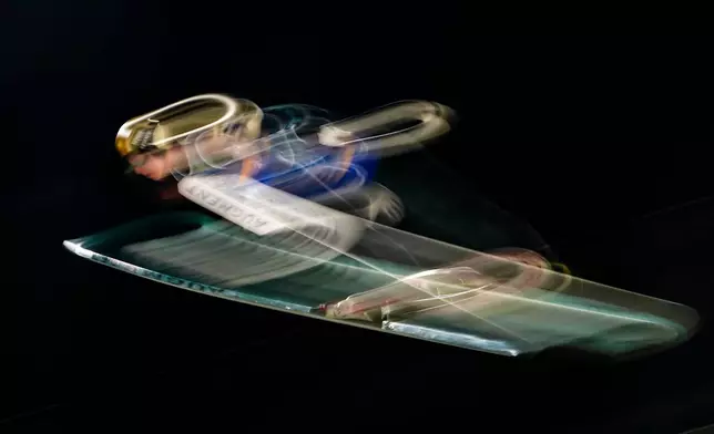 Giovanni Bresadola, of Italy, soars through the air during the ski jumping mixed team competition at the 2026 Winter Olympics, in Predazzo, Italy, Tuesday, Feb. 10, 2026. (AP Photo/Matthias Schrader)