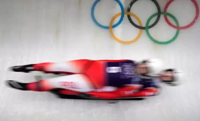 Poland's Nikola Domowicz and Dominika Piwkowska, right, slide down the track during a women's doubles luge training session at the 2026 Winter Olympics, in Cortina d'Ampezzo, Italy, Monday, Feb. 9, 2026. (AP Photo/Aijaz Rahi)
