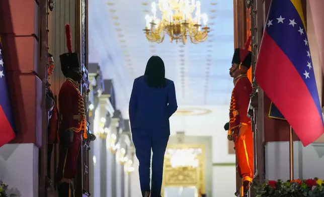 Venezuela's acting President Delcy Rodriguez walks back into Miraflores Palace after signing an amnesty bill approved by the National Assembly in front of journalists in Caracas, Venezuela, Thursday, Feb. 19, 2026. (AP Photo/Ariana Cubillos)