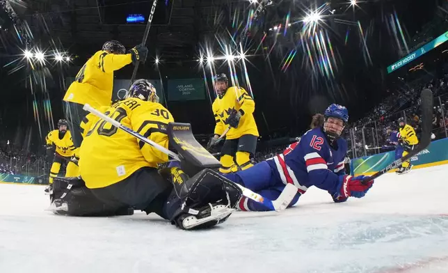 United States' Kelly Pannek (12) challenges with Sweden's Emma Soderberg (30) during a women's ice hockey semifinal game between the United States and Sweden at the 2026 Winter Olympics, in Milan, Italy, Monday, Feb. 16, 2026. (David W Cerny/Pool Photo via AP)