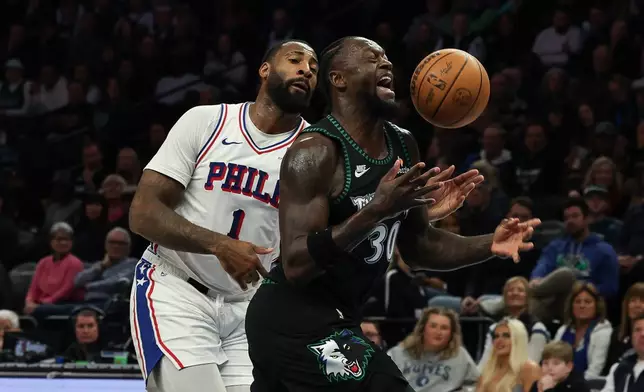 Minnesota Timberwolves forward Julius Randle (30) is fouled by Philadelphia 76ers center Andre Drummond (1) during the first half of an NBA basketball game Sunday, Feb. 22, 2026, in Minneapolis. (AP Photo/Stacy Bengs)