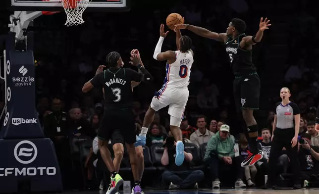 Philadelphia 76ers guard Tyrese Maxey (0) goes up to shoot against Minnesota Timberwolves guard Anthony Edwards (5) during the first half of an NBA basketball game Sunday, Feb. 22, 2026, in Minneapolis. (AP Photo/Stacy Bengs)