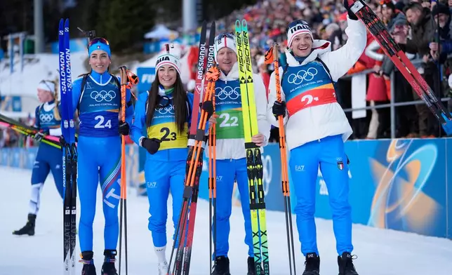 Italy's Lisa Vittozzi, from left, Dorothea Wierer, Lukas Hofer and Tommaso Giacomel celebrate winning silver in the 4X6-kilometer mixed relay biathlon race at the 2026 Winter Olympics in Anterselva, Italy, Sunday, Feb. 8, 2026. (AP Photo/Andrew Medichini)