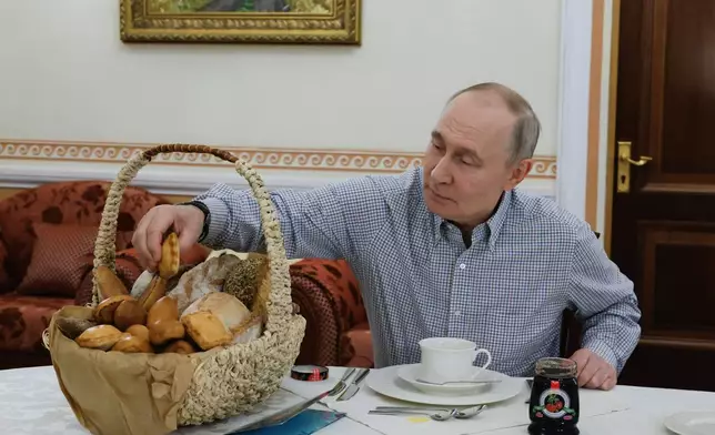 FILE - Russian President Vladimir Putin tries pastries from the Mashenka bakery in Moscow on Dec. 20, 2025, after the owner asked him about tax reforms at his annual call-in show. (Mikhail Metzel, Sputnik, Kremlin Pool Photo via AP, File)