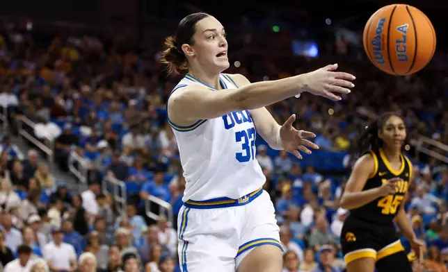UCLA forward Angela Dugalić (32) passes the ball as Iowa forward Hannah Stuelke (45) watches during the first half of an NCAA college basketball game, Sunday, Feb. 1, 2026, in Los Angeles. (AP Photo/Jessie Alcheh)